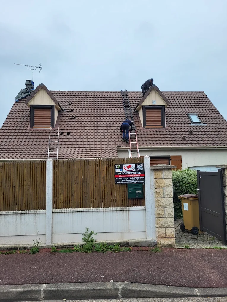 Équipe JH Couvertures sur une toiture en rénovation avec échelles et panneau